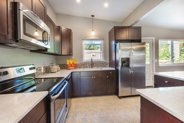 A kitchen with concealed cabinets and white quartz countertops