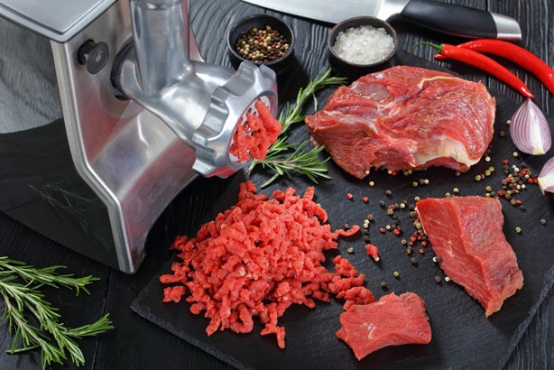 A meat grinder grinding meat 