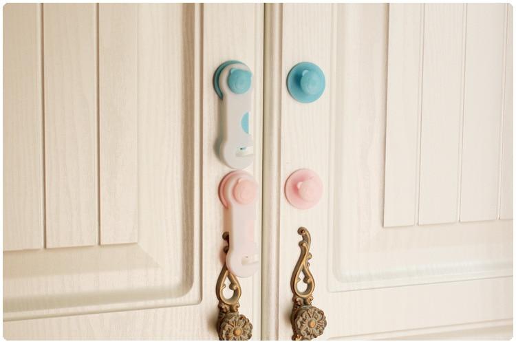 pink and blue cabinet safety locks that are attached to the cabinet door