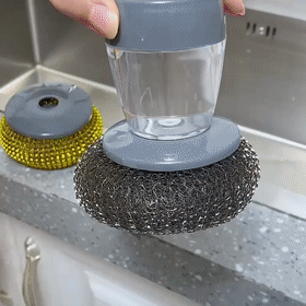 a lady cleaning kitchen wares and sink using the soap dispensing palm brush