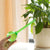 hand holding an automatic self watering flask and plant on a pot