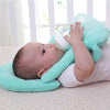 baby drinking milk while laying down on a baby nursing pillow